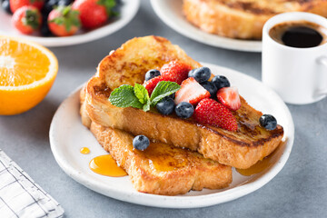 French toast with fresh berries and sweet syrup on plate served with espresso coffee. Sweet breakfast or lunch