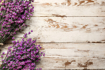 Bouquets of lavender flowers on light wooden background, closeup