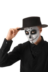 Young man with painted skull on his face against white background. Celebration of Mexico's Day of the Dead (El Dia de Muertos)