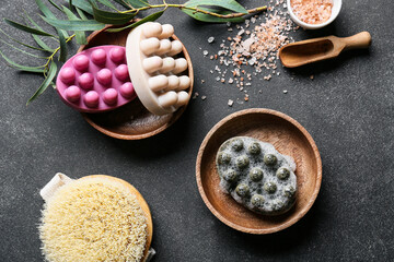 Bowl with massage soap bars, brush and sea salt on dark background