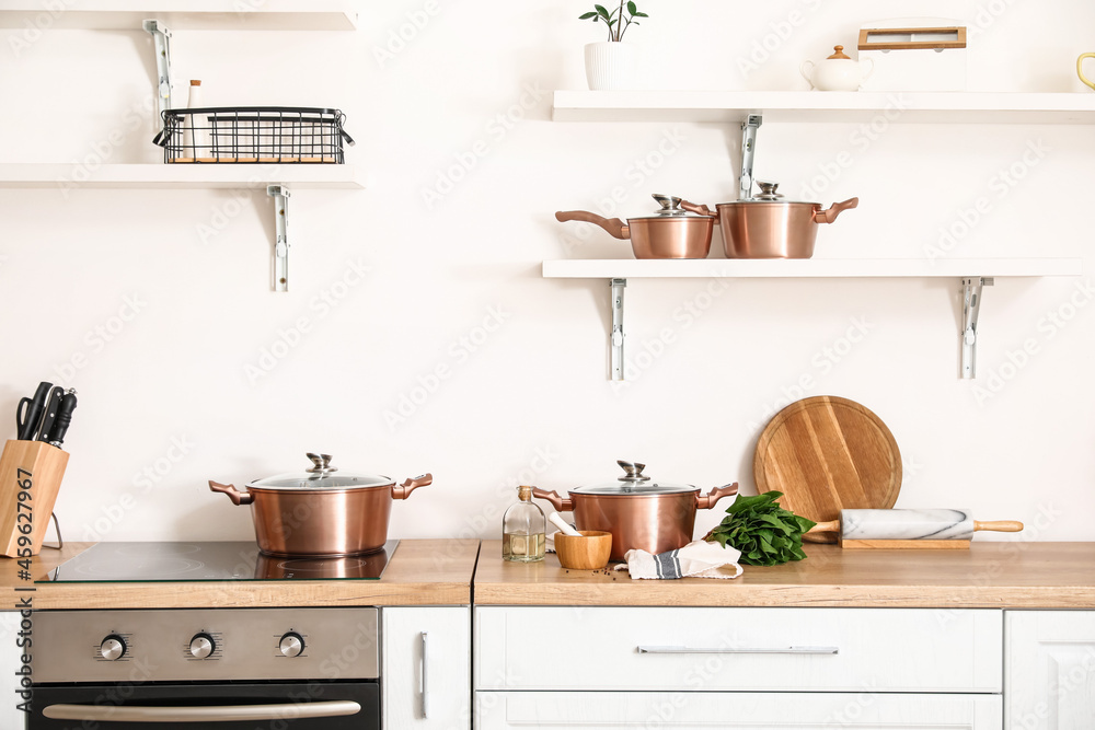 Wall mural set of cooking pots with mortar, pestle, spinach and oil on kitchen counter