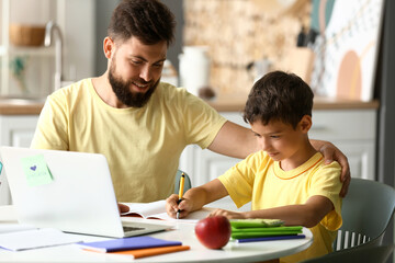 Obraz premium Little boy with his father doing lessons at home