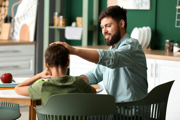 Little boy with his father doing lessons at home © Pixel-Shot