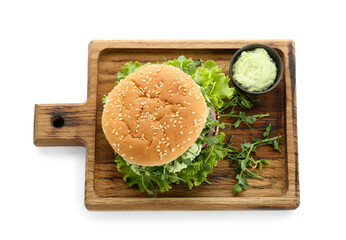 Wooden board with tasty vegetarian burger and sauce on white background