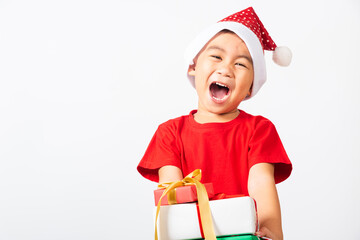 Asian little child cute boy smile and excited, Kid dressed in red Santa Claus hat hold gift box on...