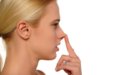 Young blond woman touches her nose with her finger