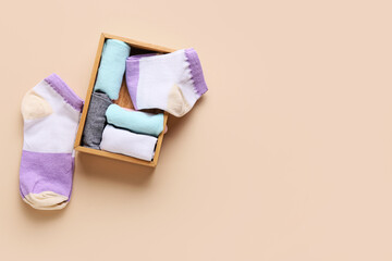 Box with stylish socks on color background