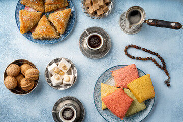 Top view of Turkish sweets and turkish coffee on light blue background