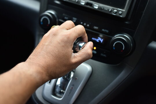 Man's hand holding an automatic gear in a car