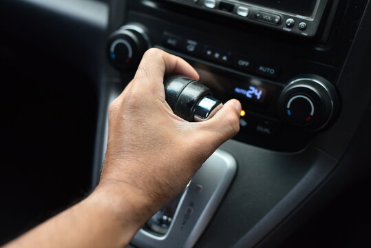 Man's hand holding an automatic gear in a car