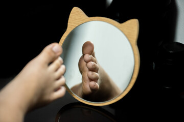 Feet in the mirror, wooden frame, animal shape with ears.