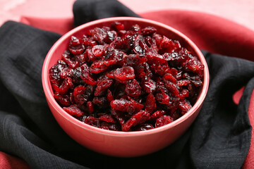 Bowl with tasty dried cranberries on table, closeup