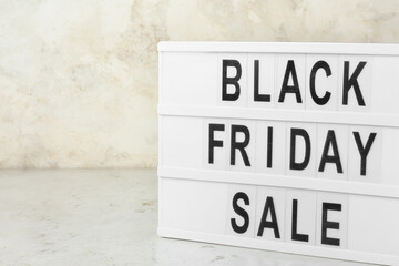 Board with text BLACK FRIDAY SALE on light background