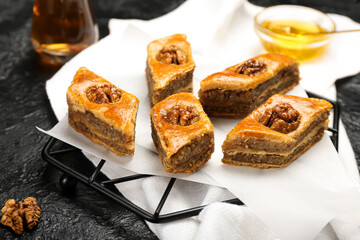 Grid with tasty baklava on dark background