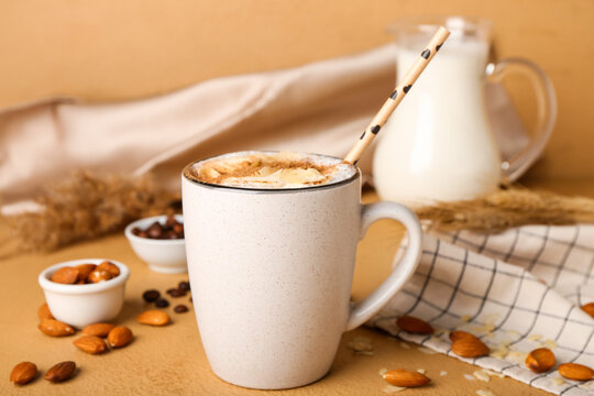 Cup Of Tasty Almond Latte With Cinnamon On Color Background