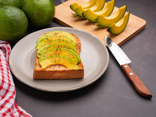 The toast then topped pepper with sliced avocado, salt, and cayenne pepper. Avocados are a versatile fruit to slice, mash, or fill. Top view. Space for text. Health fruit concept