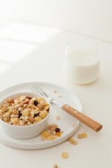 a cup of milk and oatmeal on white table.