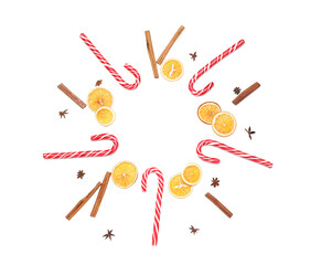 Frame made of candy canes and dried oranges on white background