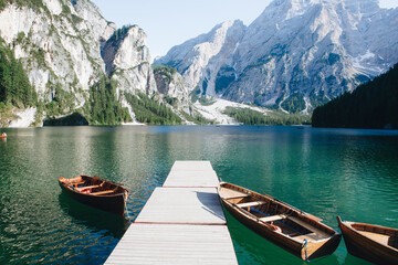 Lago di Braies in Dolomites, mountains forest trail in background, Sudtirol, Italy