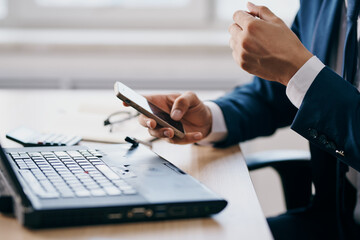 man in front of laptop at the table in front of a laptop communication manager