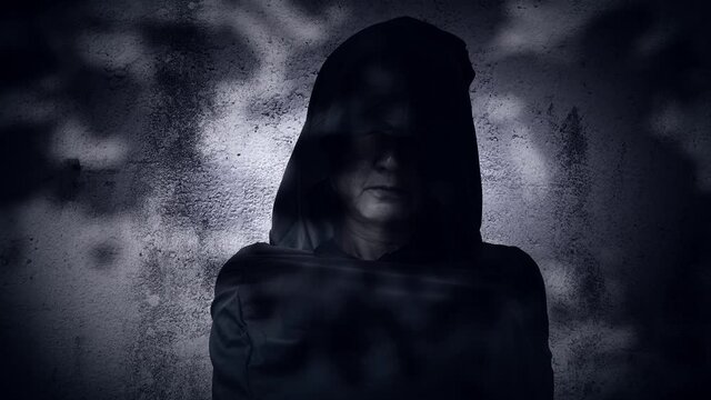 A dark, motionless figure in a hooded cloak. halloween concept.