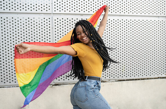 Carefree lesbian woman dancing with pride flag