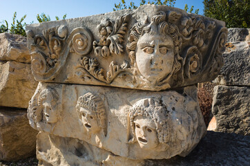Theatrical mask and face stone relief of ancient town of Myra in Lycia, Ruins of ancient city of Myra in Demre, Turkey