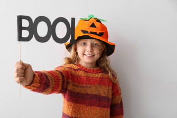 Cute little girl dressed for Halloween on light background