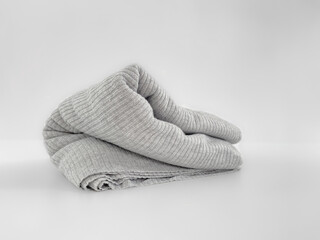 Knitted gray knitwear on a white background. Grey textiles. Folded fabric