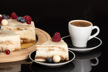 Tiramisu cake with a coffee cup on the black background