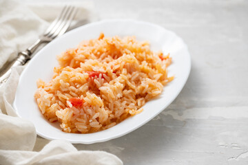 boiled rice with tomato and spices on white dish