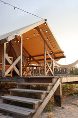 Fototapeta na wymiar Glamping tent in the forest. Luxury tent sea view. Nature green tourism