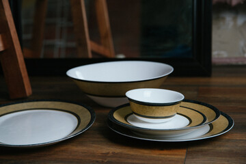 Obraz premium empty dishes, a set of artist's tableware with a beautiful ornament on a wooden table, exquisite tableware