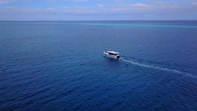 Aerial drone tracking video of luxury yacht cruising in deep blue open ocean sea. Tropical. Atlantic ocean. Between Dominican and Bahamas. Carribean sea