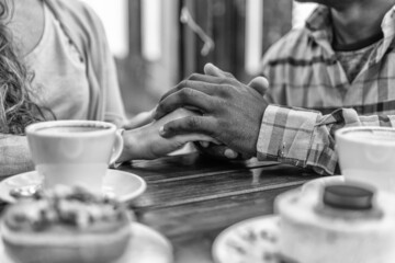 Two hands in love meet in front of sweets and coffee