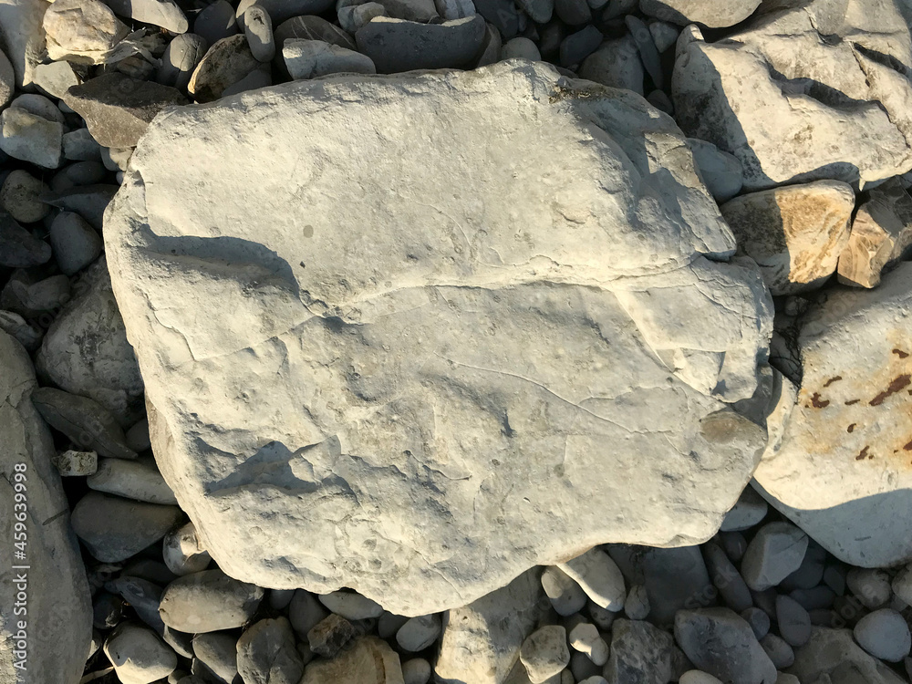 Poster a large stone lies on a sea pebble on the beach. piece of rock