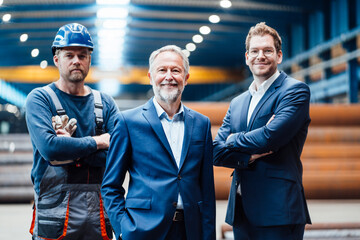 Male managing director standing with professionals in industry