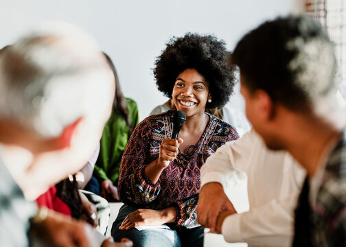 Cheerful Woman Speaking On A Microphone In A Workshop