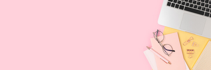 Banner with laptop and office supply on a pink background. E-learning workspace, distance education concept with copy space.