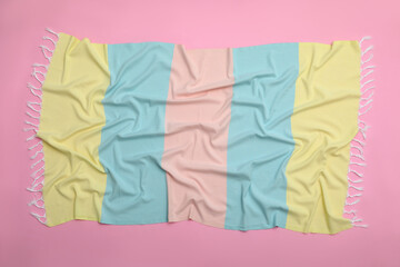 Crumpled striped beach towel on pink background, top view