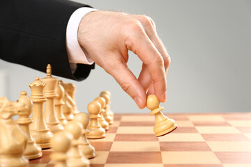 Man moving chess piece on board, closeup