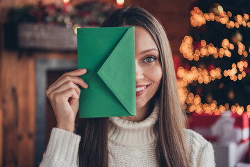 Photo portrait woman with brown hair keeping green letter in decorated apartmant