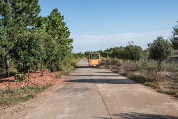 Kindergarten school bus driving on mountain village road