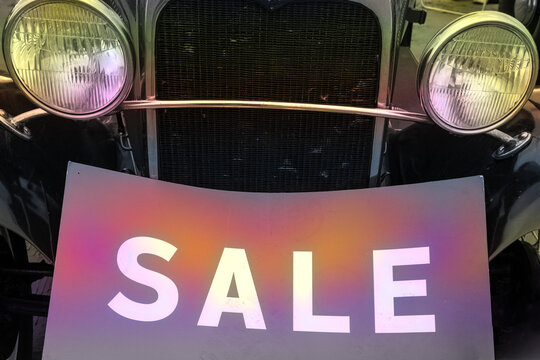 Zwei runde Scheinwerfer eines Oldtimers mit em Schild "Sale" - Powered by Adobe