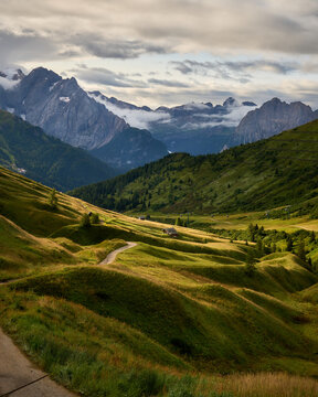 relaxing scene of typical dolomits grass pastures and high mountains in the background in the afternoon golden light