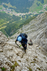 Kletterer Gruppe in einem Klettersteig hoch über dem Tal von Canazei in den italienischen Dolomiten
