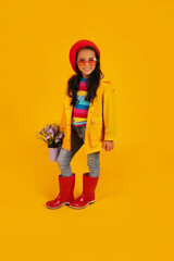 a dark-skinned girl in a red beret, pink heart-shaped glasses, a yellow raincoat, and a bucket with flowers in her hands