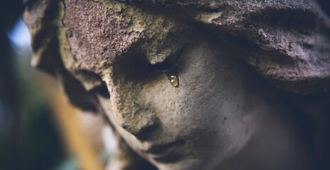 Angel's tears. Close up fragment of ancient statue of angel. The concept of death and pain....