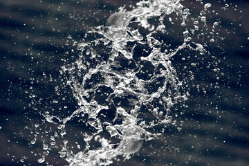 Water splashes in the center of the frame on a dark blue background