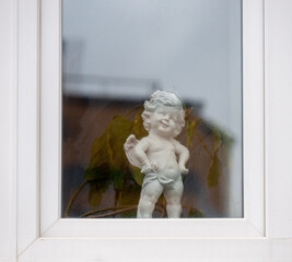 A cheerful little angel who stands in the window